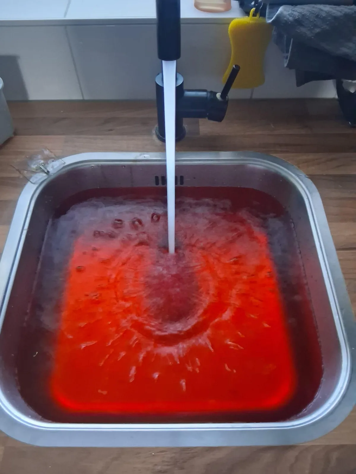 Spoelbak met rood gekleurd water