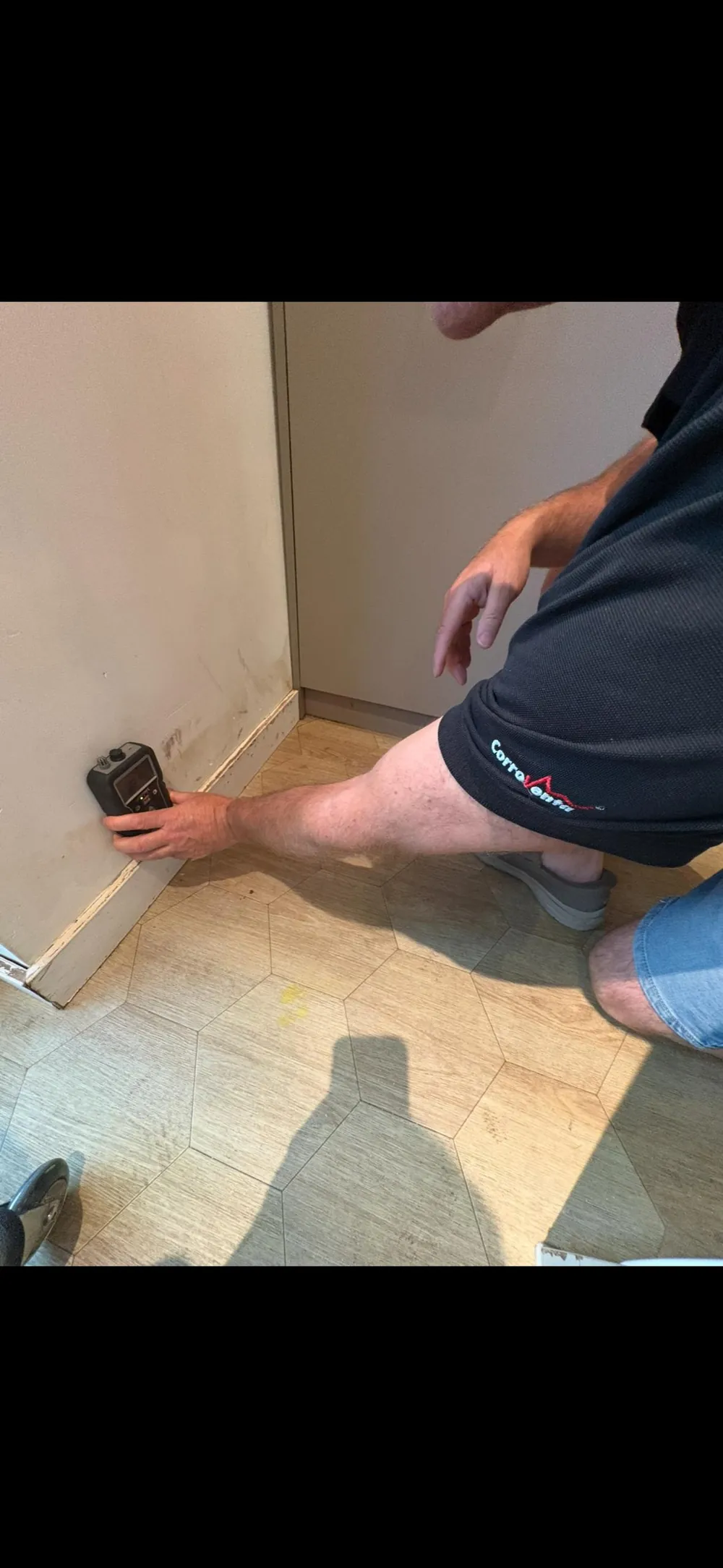 Vochtmeter tegen een wand boven de plint